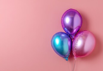 Three reflective, metallic balloons in blue, purple and pink on a plain pink background