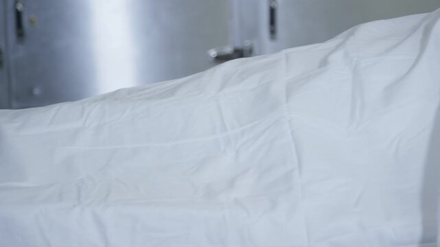 A corpse on a gurney in a hospital morgue
