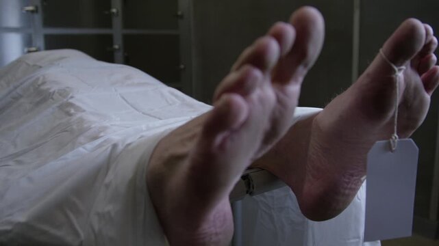 A corpse on a gurney in a hospital morgue