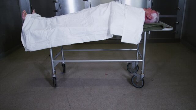 A corpse on a gurney in a hospital morgue
