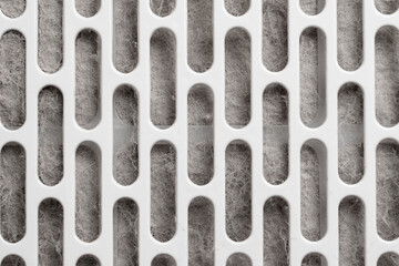 Abstract textured background of dirty fibrous air filtration material behind white plastic grille. Dusty surface. Minimal industrial design. Technical structure concept 