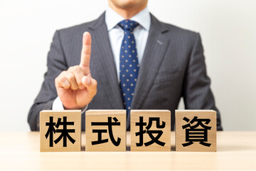「株式投資」と書かれたブロックとビジネスマン