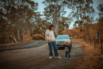 A mother and her cheerful child share a peaceful moment by the roadside