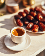 Cup of espresso coffee accompanied by sweet dates in a cozy setting.