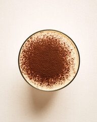 Top view of a cappuccino with cocoa powder dusting in a glass cup.