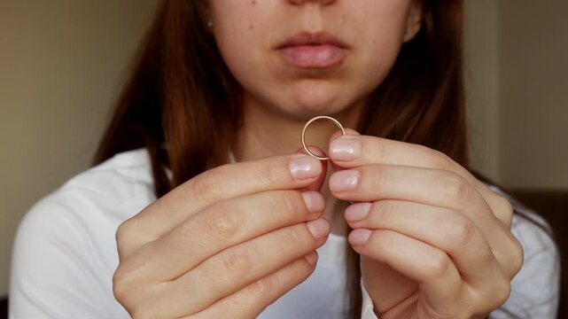 Close-up of a woman's hand with a wedding ring. A broken heart, divorce, and a painful farewell.