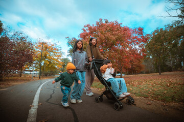 A joyful family enjoying a walk in a vibrant autumn park full of colorful leaves