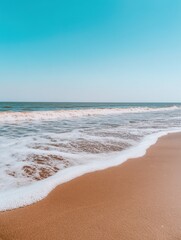 Serene Beach Waves Gently Lapping on Golden Sand Under Clear Blue Sky