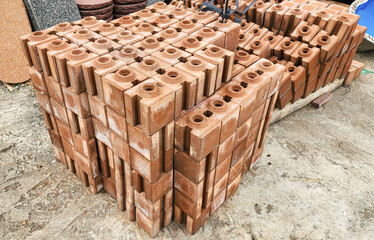 Stacked concrete bricks with hollow cores at a construction site, showing raw texture and earthy tones, representing building materials, industrial manufacturing, and infrastructure development.