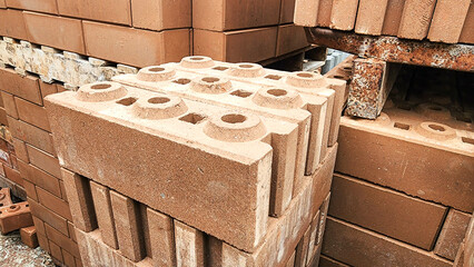 Stacked concrete bricks with hollow cores at a construction site, showing raw texture and earthy tones, representing building materials, industrial manufacturing, and infrastructure development.