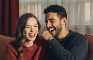 Obraz premium Happy couple laughing together at home, sharing joy, love and positive emotions. Realistic Valentine’s Day lifestyle photography.