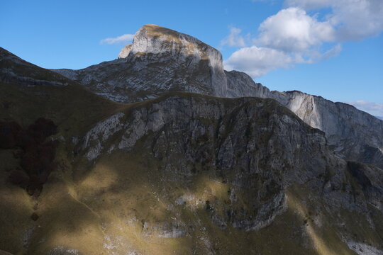 Scenic mountain landscape with rugged cliffs and a partly cloudy blue sky, showcasing natural beauty and outdoor adventure appeal of Apuan Alps' mount Sumbra.