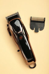 Hair clipper on beige background. Modern hair clipper. Vertical photo