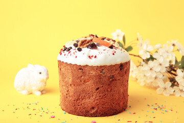Traditional easter cakes with colorful sprinkles, with eggs, a bunny figurine, and spring flowers, creating a festive holiday scene