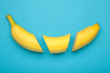 Cut banana, slices on pastel blue background. Minimalist concept.