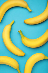 Yellow bananas flat lay on blue background. Vertical photo