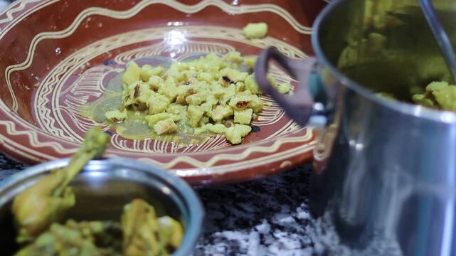 Moroccan Rfissa (Madhoussa) with Slow-Cooked Chicken, Lentils, Semolina Crumbles, and Herbs in Traditional Brown Ceramic Bowl with Garlic Garnish