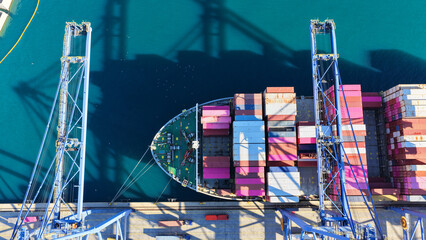 Aerial drone top down photo of huge fully loaded Container ship anchored in loadingunloading logistics terminal port © aerial-drone