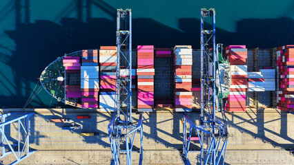 Aerial drone top down photo of huge fully loaded Container ship anchored in loadingunloading logistics terminal port © aerial-drone