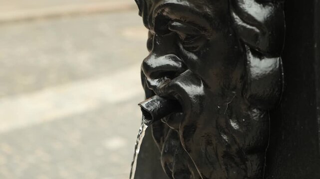 a small fountain in the shape of a faun's face