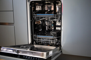 Built-in dishwasher in the kitchen, washing dishes. Plates, cups, glasses are worth washing. Household chores, everyday life