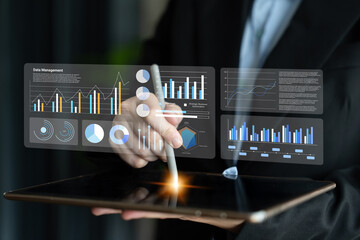 A business professional engages with a digital tablet showcasing interactive graphs and charts that illustrate key data management and analytics in a modern office setting. Gantry