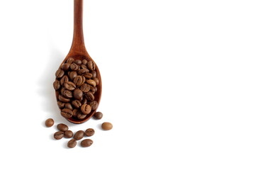 Obraz premium On a white background lies a wooden spoon with coffee beans.