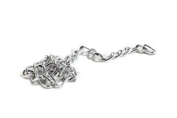  On a white background lies a large silver chain in a pile.