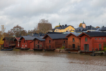 Cityscape with old red barns on the banks of the Porvoonjoki River on a cloudy October day. Porvoo, Finland