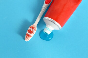 Toothpaste with a brush is on a blue background.