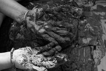 Young woman sculpting clay idol by hand during traditional craft process