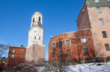 Ancient Clock Tower in the city landscape on a March day. Vyborg, Leningrad region. Russia