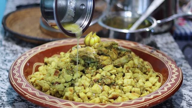 Moroccan Rfissa (Madhoussa) with Slow-Cooked Chicken, Lentils, Semolina Crumbles, and Herbs in Traditional Brown Ceramic Bowl with Garlic Garnish