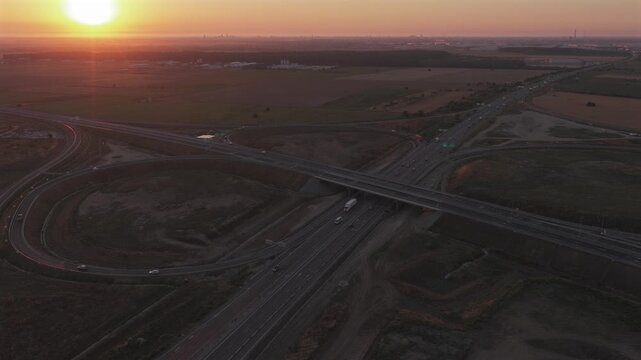 Bucharest A0 highway 4k video. Aerial view of a curved section of the A0 highway near Bucharest during the warm light of sunrise, highlighting the road lines and safety barriers. Roads of Romania.
