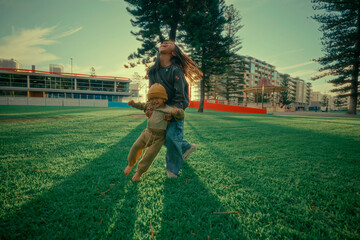 A child runs happily across the grass holding a toy, embodying pure joy.