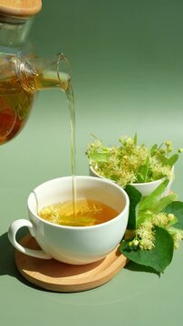 Herbal linden tea pouring into a white cup