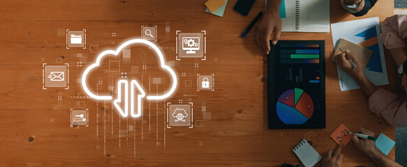 A modern workspace showcasing cloud computing concepts, featuring team collaboration, digital icons, and data visualization in an office environment. Trope
