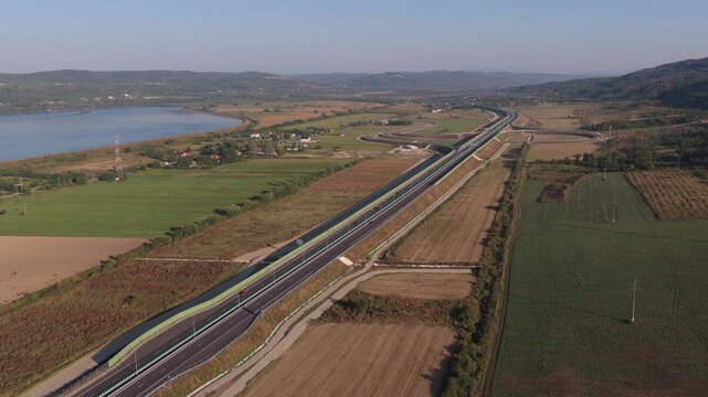 A1 highway from Bucharest to Pitesit Curtea de Arges and Sibiu 4K video. Newly built A1 Highway in Romania, cutting through rural fields and valleys, with mountains visible in the distance.
