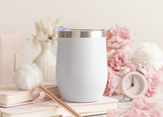 White blank 12oz wine tumbler near pink decor and flowers, pastel spring valentines mockup, closeup