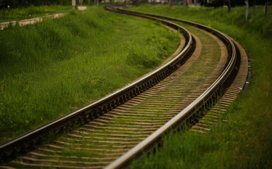 Curved Railroad Track Passing Through Green Grassy Field Landscape