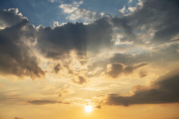Dramatic sky with clouds and golden sunlight at sunset. Natural background showing peaceful evening atmosphere, hope and inspiration. Ideal for nature, weather and spirituality.