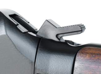 Cocked hammer on a lever action rifle with wood stock seen up close and isolated on a transparent png background