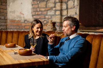 Couple enjoys drinks and food in cozy restaurant setting at night