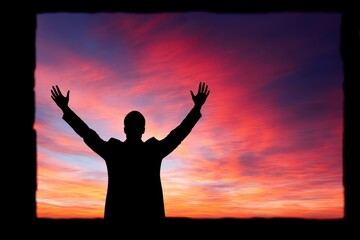 Fototapeta premium A silhouette of a person raising their arms against a vibrant sunset, conveying a sense of freedom and celebration.