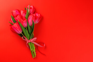 Red tulip bouquet on a soft red background