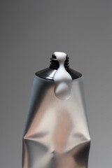 A sleek, silver metal tube for cream squeezed to show product use on a gray background. Clean, modern, and minimalist product photography ideal for cosmetics, skincare, or pharmaceutical advertising.