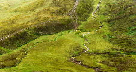 Streams and paths crisscross a green grassy landscape. The area is likely for hiking and is located within the Coomloughra Horseshoe region.