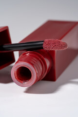 Closeup Of Red-Pink Lip gloss With Applicator In A Luxury square Bottle For Fashion Makeup