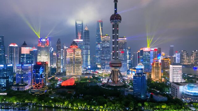 Aerial view of the illuminated Shanghai city skyline at night, featuring the Oriental Pearl TV Tower and modern skyscrapers in Lujiazui, along the Huangpu River, Shanghai.
