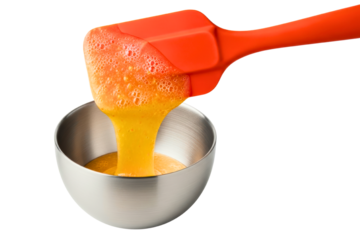 Red silicone spatula pouring beaten egg into small stainless bowl isolated on transparent background